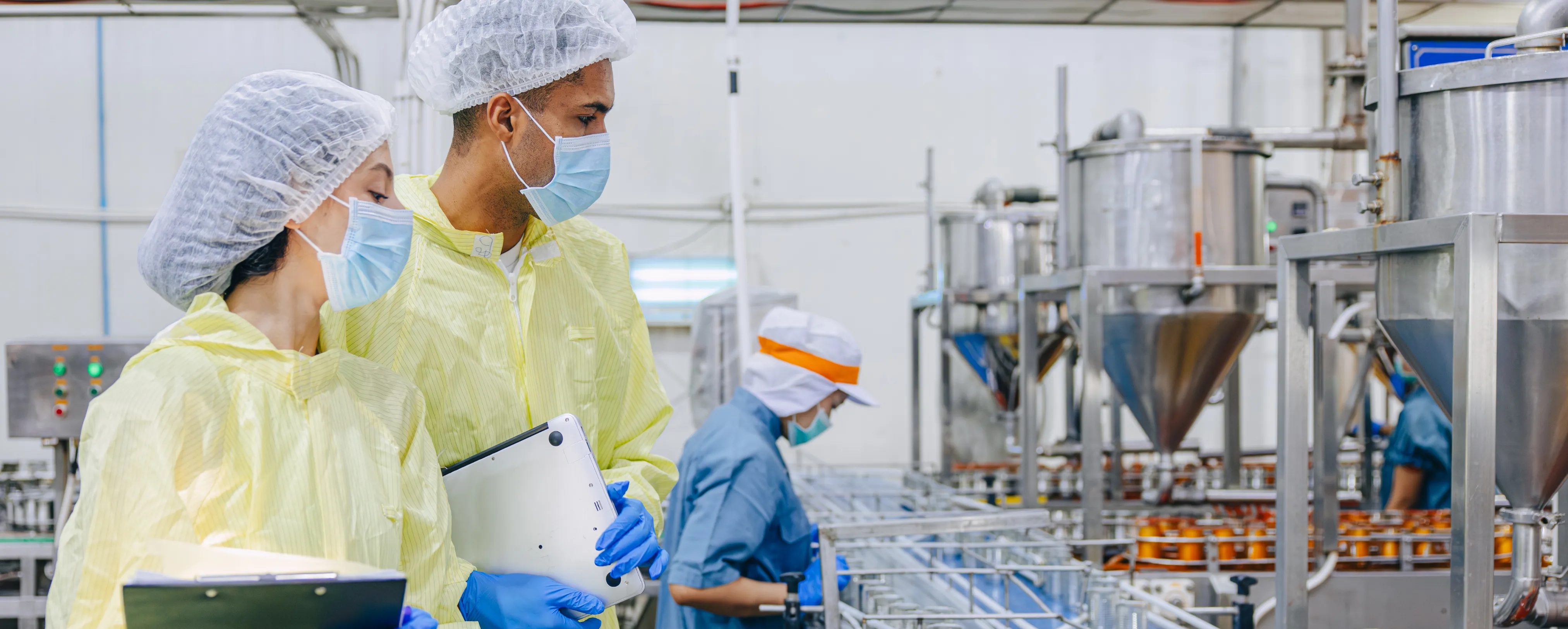 Worker in food production facility monitoring equipment